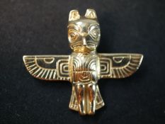 A 14 carat Native American totem pendant of a winged creature with engraved detailing. Stamped