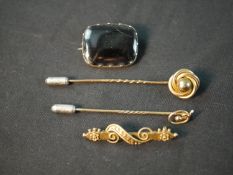 A collection of yellow metal and gold jewellery, including a 9ct art nouveau stick pin, a rolled