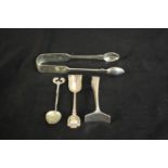 A collection of silver, including a pair of silver sugar tongs a pusher and two teaspoons one with