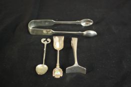 A collection of silver, including a pair of silver sugar tongs a pusher and two teaspoons one with