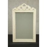 A white painted carved framed bow motif wall mirror. H.67 W.40cm.