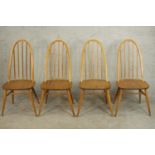 A set of four Ercol elm and beech hoop back Quaker dining chairs, with turned legs and H stretchers,