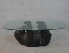 A contemporary glass topped coffee table supported by a moulded and painted bear. H.41 W.105 D.