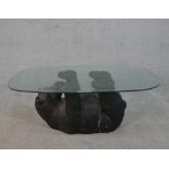 A contemporary glass topped coffee table supported by a moulded and painted bear. H.41 W.105 D.