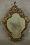 A 19th century Rococo Revival giltwood wall mirror, of cartouche form, the frame ornately carved