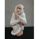 An Italian white glaze terracotta monkey holding its tail, stamped Made in Italy. H.40 W.22cm