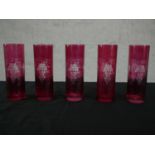 A set of five early 20th century etched vine design cranberry glass glasses. H.17 Dia.6cm.