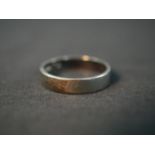 An 18ct white gold wide flat wedding band. Stamped 18, London. Weight 4.11g. Ring size O.