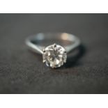 An 18 carat white gold solitaire diamond ring, set with a round old cut diamond in an open back