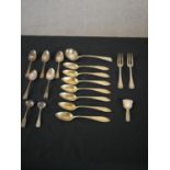 A collection of silver cutlery, including an Ionian silver caddy spoon, a set of seven German gilded