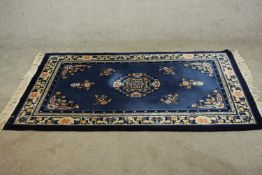A blue ground hand made Continental Chinese woollen rug. L.183 W.120cm.