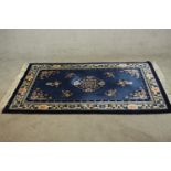 A blue ground hand made Continental Chinese woollen rug. L.183 W.120cm.