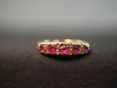 A Victorian 18ct yellow gold carved half hoop five stone ruby ring. Set with five round mixed cut