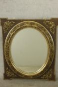 An early 20th century gilt framed wall mirror, of rectangular form with an oval mirror plate, the