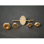 A yellow metal (tests as 9ct) engraved monogram bar brooch along with three 9ct shirt studs and a