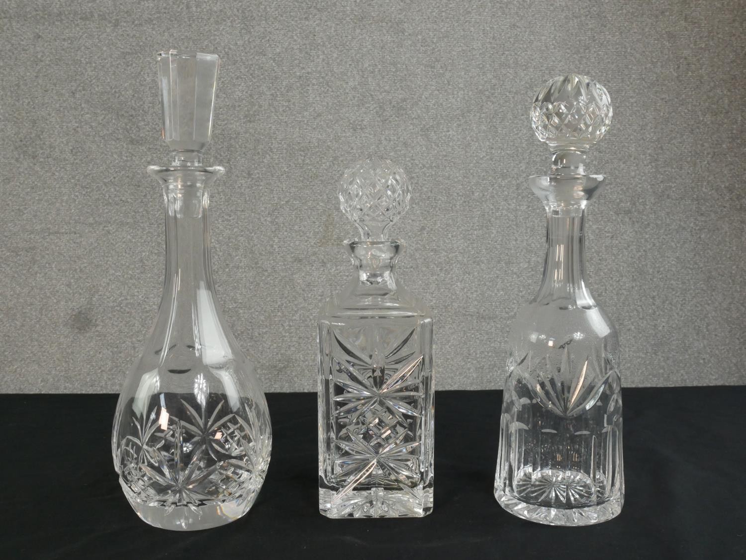 Three cut glass and crystal decanters, each of different design. H.35cm (largest)