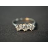An Edwardian platinum and diamond three stone diamond ring, set to centre with a round old cut