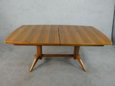 A 1960s Gordon Russell Ltd teak extending dining table, with a butterfly leaf. H.75 W.230 D.104cm (