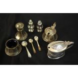 A collection of silver items, including a three piece cruet set, miniature pepper shakers and a