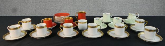A collection of hand painted and gilded part coffee sets, including a T. Goode and Co orange and