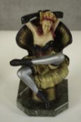 After Chiparus, an Art Deco style resin figure of a female dancer posing on a chair on marble effect