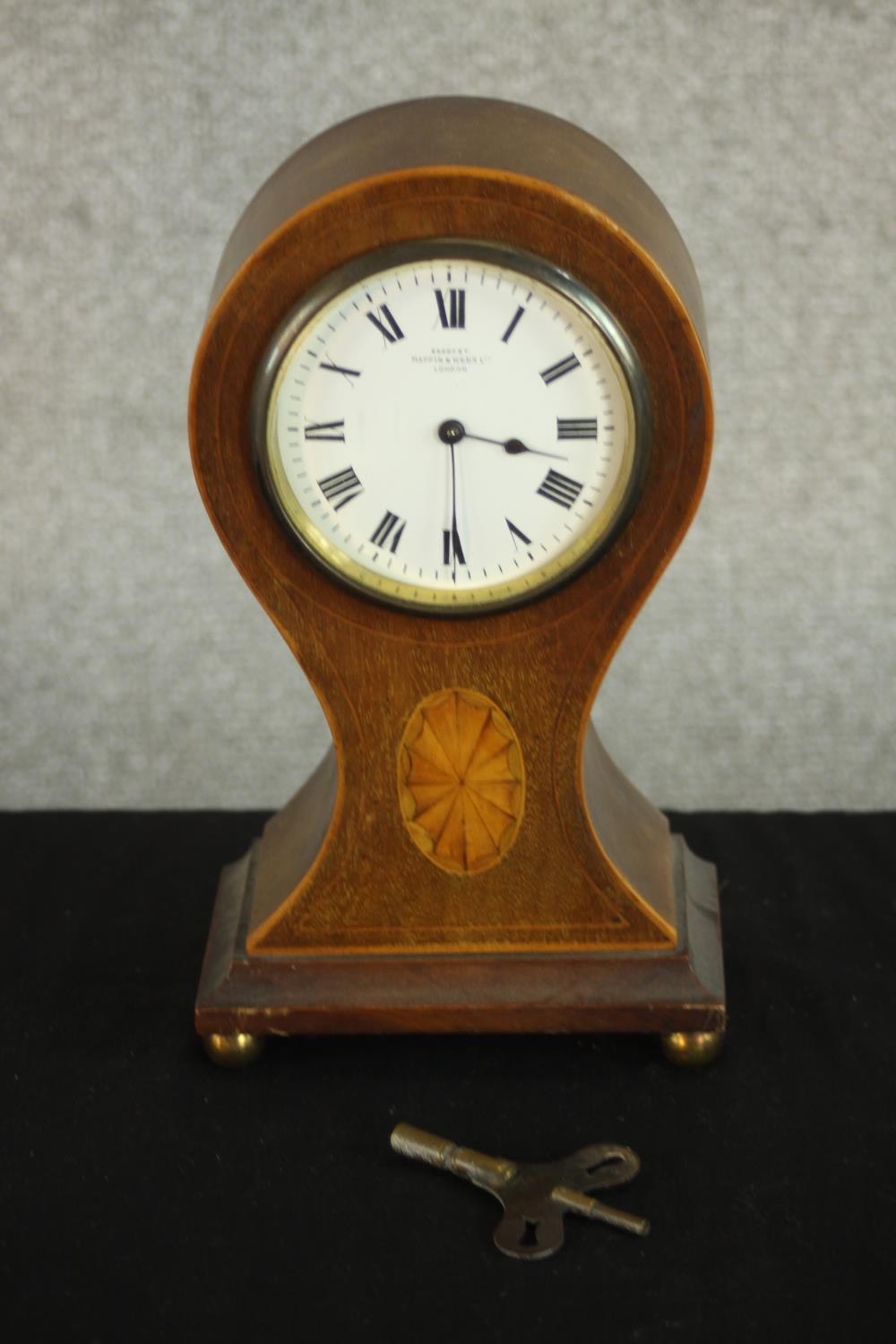 An Edwardian walnut and marquetry inlaid balloon mantel clock, the case inlaid with an oval