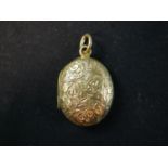 A Victorian 18ct yellow gold oval engraved locket, the front decorated with a scrolling foliate