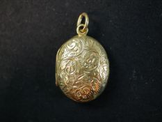 A Victorian 18ct yellow gold oval engraved locket, the front decorated with a scrolling foliate