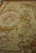 An Aubusson style needlepoint carpet with central floral cartouche within foliate spandrels and