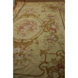 An Aubusson style needlepoint carpet with central floral cartouche within foliate spandrels and