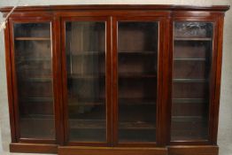 A Victorian walnut full height breakfront bookcase, with four glazed doors enclosing shelves on a