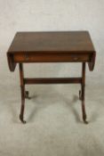 A reproduction George III style mahogany sofa table with a crossbanded top and drop leaves over a