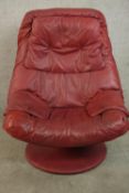 A late 20th century Stressless style scarlet leather reclining armchair with padded arms on a