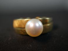An 18ct yellow gold and cultured pearl dress ring, set to the centre with a round white cultured