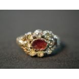 A 19th century red metal and silver closed back garnet and paste cluster ring, set to the centre