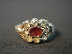A 19th century red metal and silver closed back garnet and paste cluster ring, set to the centre