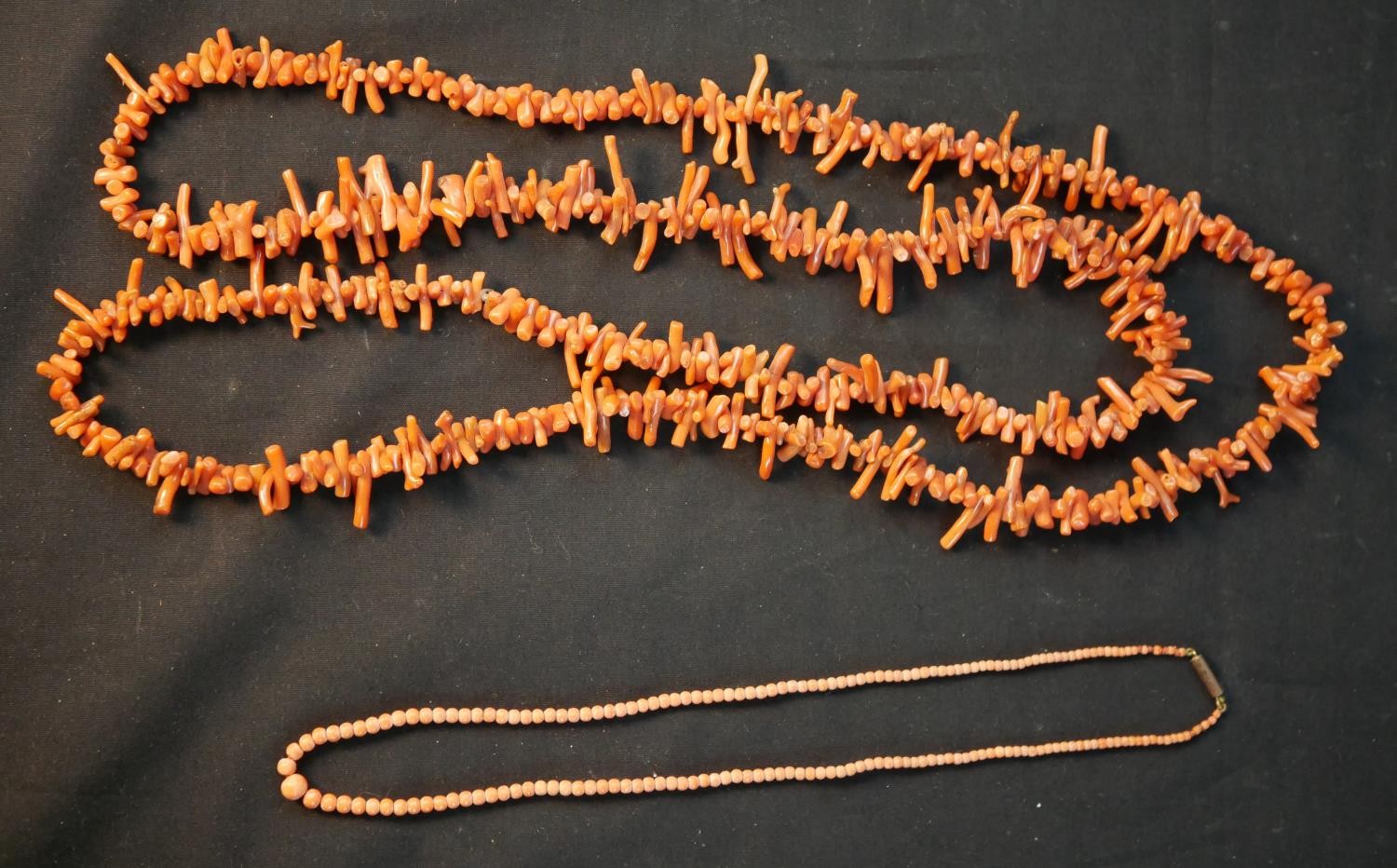 A long early 20th century orange branch coral necklace along with a Victorian graduated coral bead
