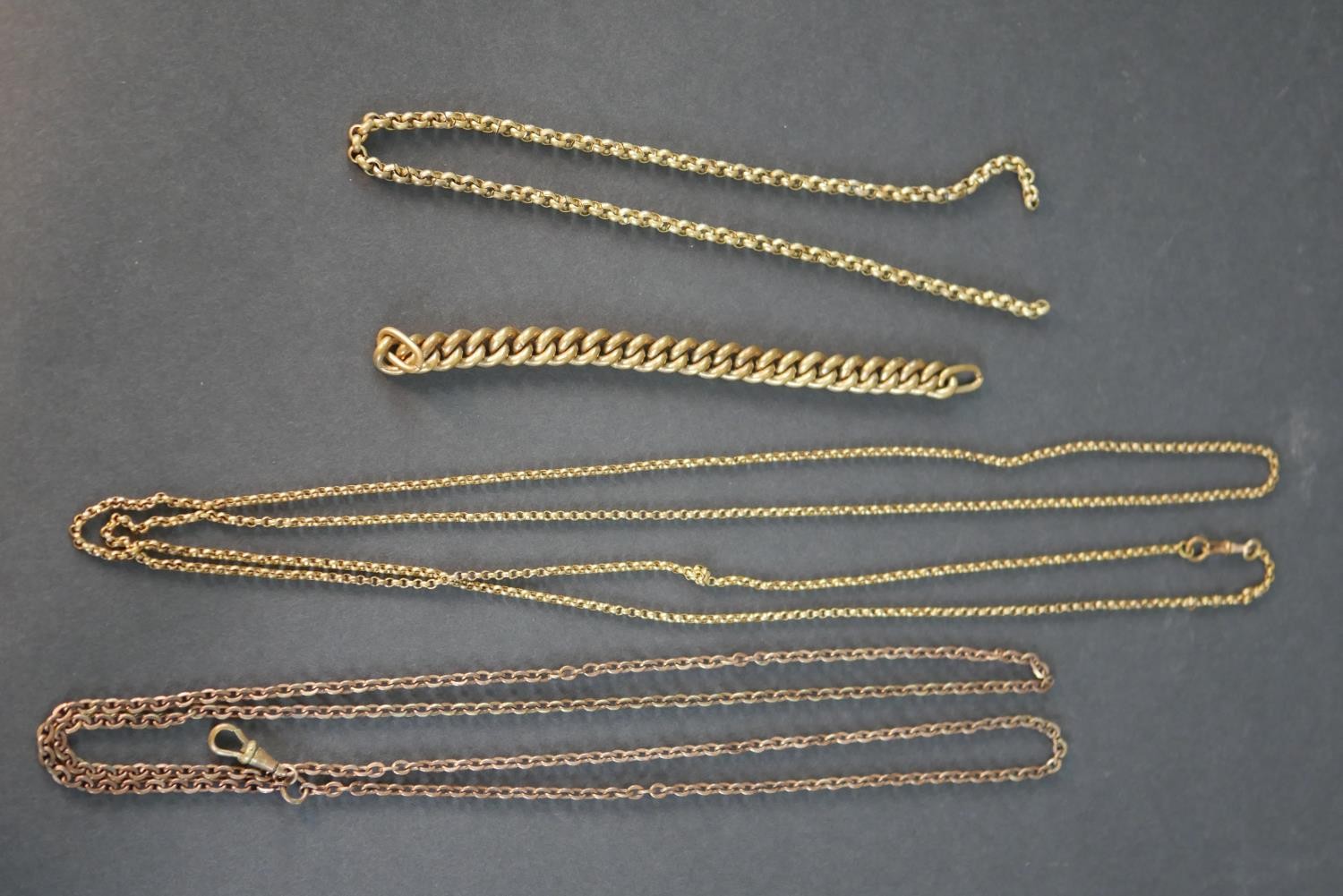 A collection of rolled Victorian chains, including two rolo link long watch chains with Albert