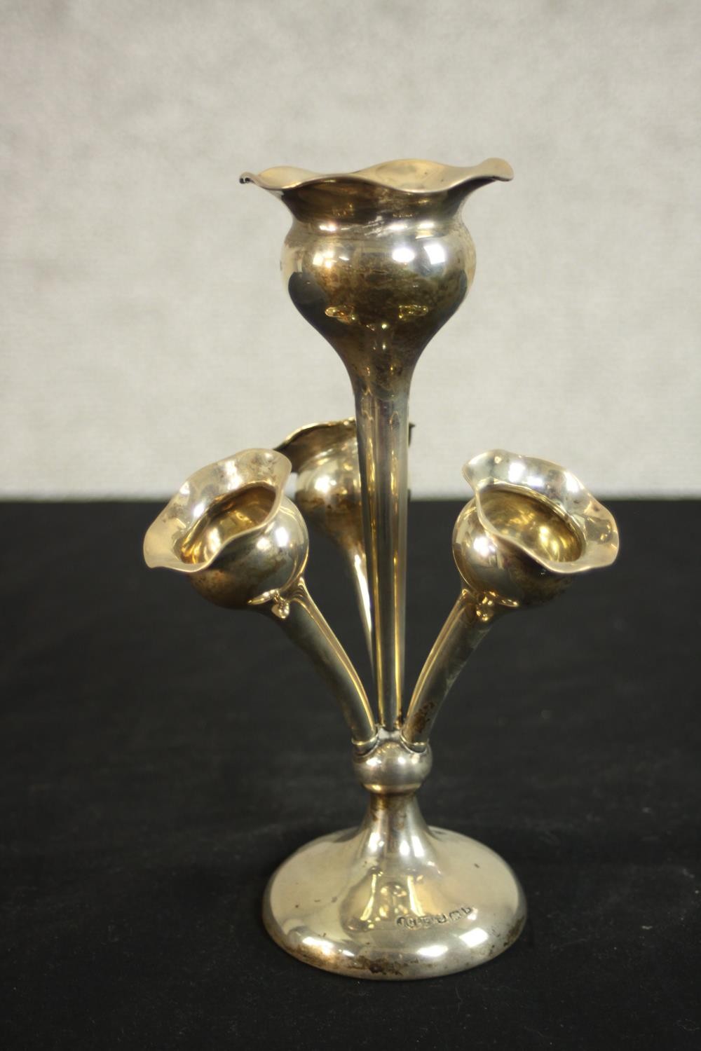 A weighted base Edwardian sterling silver four branch epergne with three trumpet vases.
