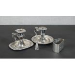 A pair of late 19th - early 20th Century silver plate candleholders, one including a snuffer along