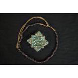 A Tibetan silver and turquoise Gau box pendant along with a string of graduated garnet beads on gold