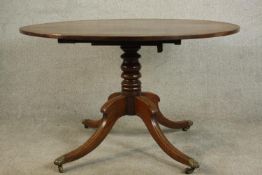 A mid 19th century mahogany tilt top breakfast table, with a circular crossbanded top on a turned