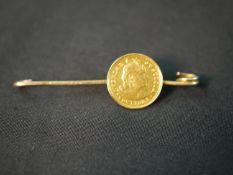 A yellow metal gold bar brooch set with a Peru 1/5 libra gold coin. (pin broken) Weight 2.52g