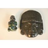 A carved green hardstone Mayan/Aztec mask along with a stone figure of a man. H.18 W.14cm. (largest)