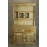 A 20th century pine dresser, the upper section with two shelves incorporating a pair of leaded glass