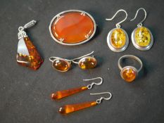 A collection of Amber jewellery and a carnelian and silver oval brooch. Amber jewellery includes,