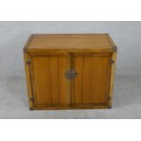 A late 20th century Chinese hardwood television cabinet, with two folding doors, steel lock and