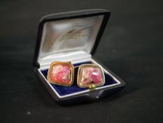 A pair of 14 carat yellow gold Tugtupite cabochon set cufflinks with hinged torpedo fittings.