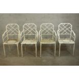 A set of four vintage white painted wrought iron garden chairs, with faux bamboo cockpen backs and