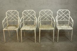 A set of four vintage white painted wrought iron garden chairs, with faux bamboo cockpen backs and